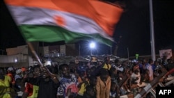 FILE - Supporters of Niger's National Concil for the Safeguard of the Homeland display a National flag as they protest ouside a French and Niger airbase in Niamey on Sept. 9, 2023 to demand the departure of the French army from Niger. 