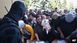 Евакуирани луѓе во регионот Курск чекаат да пополнат формулари за хуманитарна помош во центарот за дистрибуција на помош во Курск, Русија, 14 август 2024 година