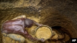 FILE - Miners extract mud at a gold mining site where adults and youth work in Uganda, Oct. 18, 2021. As the race to acquire economically vital minerals unfolds, those in Africa’s mining sector are calling to protect the women and children laborers who keep it running. 