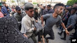 Palestinians carry a wounded person following an Israeli airstrike near Al-Aqsa hospital, in Deir al Balah, Gaza Strip, March 31, 2024.