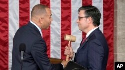 U.S. House Minority Leader Hakeem Jeffries, D-N.Y., hands the gavel to Speaker-elect Mike Johnson, R-La., at the Capitol in Washington, Oct. 25, 2023.