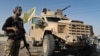 A U.S.-backed Syrian Democratic Forces fighter stands next to an armored vehicle at al-Sabha town in the eastern countryside of Deir el-Zour, Syria, Sept. 4, 2023.