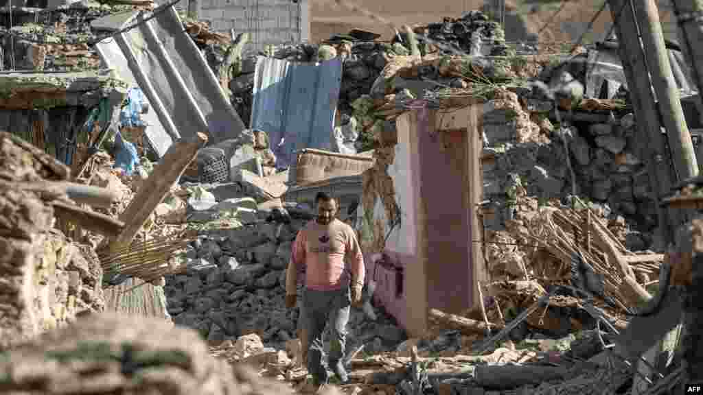 A man walks past destroyed houses after an earthquake in the mountain village of Tafeghaghte, southwest of the city of Marrakesh, Morocco, on Sept. 9, 2023.