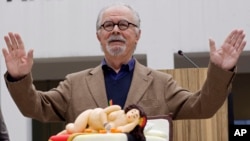 El artista colombiano Fernando Botero hace un gesto frente a su pastel de cumpleaños en la celebración de su 80 cumpleaños en el Museo Botero en Bogotá, Colombia, el jueves 19 de abril de 2012. (Foto AP/William Fernando Martinez)