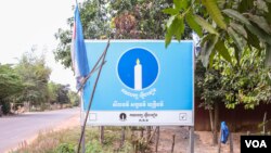 រូបឯកសារ៖ ផ្លាកគណបក្សភ្លើងទៀនត្រូវបានដាក់នៅក្បែរផ្លូវជាតិមួយស្ថិតនៅមុខគេហដ្ឋានរបស់លោក ចេក រ៉ុច សមាជិកក្រុមប្រឹក្សាឃុំរ៉ុនតាឯកមកពីគណបក្សភ្លើងទៀន ក្នុងខេត្តសៀមរាប កាលពីថ្ងៃទី ១២ ខែកុម្ភៈ ឆ្នាំ ២០២៣។ (ទែន សុខស្រីនិត/វីអូអេ)