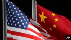 FILE - The American and Chinese flags wave at Genting Snow Park, Feb. 2, 2022, in Zhangjiakou, China. 