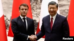 El presidente chino, Xi Jinping (derecha), y el presidente francés, Emmanuel Macron, se dan la mano en una ceremonia de firma en el Gran Salón del Pueblo, en Beijing, China, el 6 de abril de 2023. REUTERS/Gonzalo Fuentes
