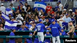 El lanzador de Nicaragua Erasmo Ramírez (61) celebra con el entrenador de pitcheo Cairo Murillo (4) en la cuarta entrada contra Venezuela en LoanDepot Park en Miami, Florida, EEUU. Foto proporcionada a Reuters por Sam Navarro-USA TODAY Sports.