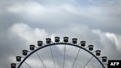 FILE - Clouds hang over a Ferris wheel during the Oktoberfest beer festival in Munich, southern Germany, Sept. 17, 2022. A Ferris wheel caught fire Saturday night at a music festival near Leipzig in eastern Germany, injuring at least 23 people, 