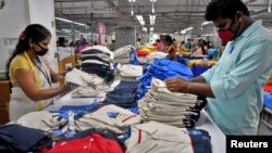 資料照片: 2022年2月9日印度一家紡織廠工人在包裝衣服前進行品質檢查