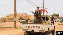 FILE - A fighter for Coordination of Azawad Movements patrols through town during the Congress for the Fusion of Movements in Kidal, Aug. 28, 2022.