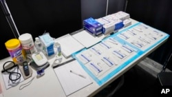FILE - COVID tests are set up inside the medical intake tent at a shelter in New York on Aug. 15, 2023.