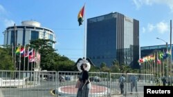 Una mujer camina por la plaza central de Georgetown con el Pegasus Suites Corporate Center un edificio de 12 pisos que es el más alto del país, se ve al fondo en Georgetown, Guyana, el 17 de febrero de 2022.