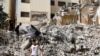 Niños palestinos caminan entre los escombros de edificios dañados después de un ataque israelí al campamento de Jenin en la Cisjordania ocupada por Israel, el 23 de mayo de 2024.