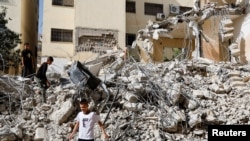 Niños palestinos caminan entre los escombros de edificios dañados después de un ataque israelí al campamento de Jenin en la Cisjordania ocupada por Israel, el 23 de mayo de 2024.