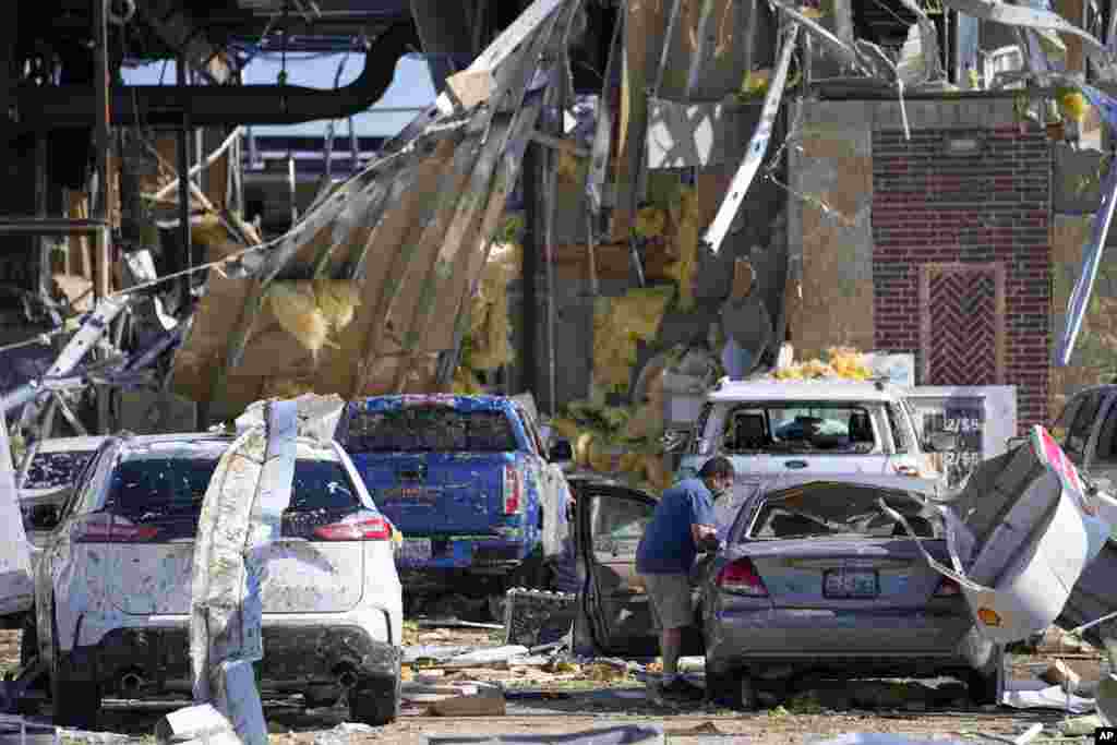 Hugo Parra of Farmers Branch, Texas, collects belongings from his vehicle after he rode out a tornado with about 40 others in the bathrooms of a truck stop the previous night, May 26, 2024, in Valley View, Texas.