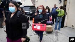 Funcionarios del servicio público de Operaciones de Emergencias del Condado Los Ángeles salen de la Iglesia católica croata de San Antonio, en Los Ángeles, tras evaluar a varios migrantes alojados en la ciudad el miércoles 14 de junio de 2023.
