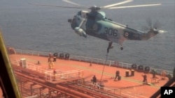 In this frame grab from video footage released April 28, 2023, by the Iranian Navy, Iranian marines rappel onto the Advantage Sweet, a Marshall Islands-flagged oil tanker's deck in the Gulf of Oman.