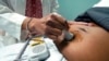 FILE - A doctor uses a hand-held probe on a pregnant woman to measure the heartbeat of her fetus, in Jackson, Mississippi, Dec. 17, 2021.