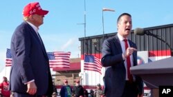 ARCHIVO - El candidato presidencial republicano y expresidente Donald Trump, izquierda, escucha mientras el candidato al Senado, Bernie Moreno, habla en un mitin de campaña el 16 de marzo de 2024, en Vandalia, Ohio.