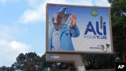 FILE - A defaced billboard of Gabon's ousted president, Ali Bongo, is seen on a street in Libreville, Gabon, Aug. 30, 2023. 