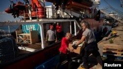 Anggota LSM "Open Arms" membawa bantuan kemanusiaan untuk dikirim ke Gaza dalam misi bersama antara LSM Open Arms dan World Central Kitchen di pelabuhan Larnaca, Siprus. 