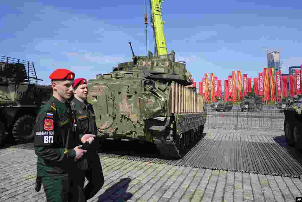 Soldados de la policía militar rusa pasan junto a un vehículo de combate Bradley M2A2. Los blogueros militares rusos establecieron paralelismos entre la muestra y las exhibiciones de equipo militar nazi capturado que la Unión Soviética mantuvo durante y después de la Segunda Guerra Mundial.
