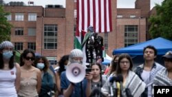 La gente habla con la prensa mientras se reúne en un campamento para apoyar al pueblo de Palestina durante una protesta en la Universidad George Washington, el 6 de mayo de 2024, en Washington.