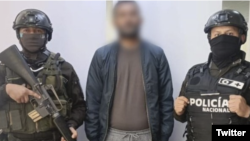 La policía difundió esta fotografía, de dos uniformados que acompañan a Abdirizak E., ciudadano detenido. [Foto: Twitter policía de Ecuador]