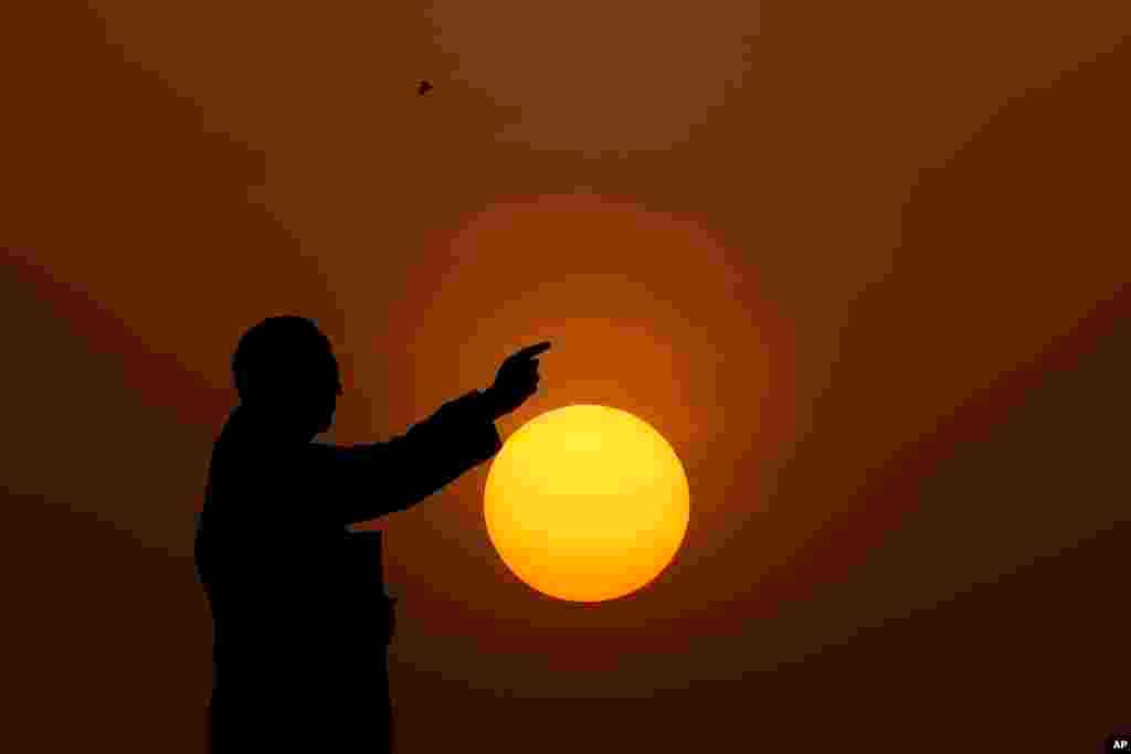 The sun sets behind a statue of Bhimrao Ramji Ambedkar, the chief architect of the Indian Constitution, in Hyderabad, India.