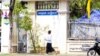 A student walks pass a sign "Thank You, Peace" in front of the Chatomuk Secondary School in Phnom Penh, on Monday, March 20, 2023. (Ten Soksreinith/VOA Khmer)
