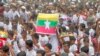 Pengungsi Rohingya berkumpul di tengah hujan, dengan bendera Myanmar terlihat di tengah, untuk menuntut pengembalian yang aman ke negara bagian Rakhine di Myanmar saat menandai ulang tahun ketujuh eksodus mereka di distrik Cox's Bazar, Bangladesh, 25 Agustus 2024.