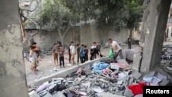 Warga Palestina memeriksa lokasi serangan Israel di sebuah rumah di Rafah, di Jalur Gaza selatan, 25 April 2024. (REUTERS/Hatem Khaled)