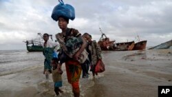FILE — Displaced families arrive after being rescued by boat from a flooded area of Buzi district, 200 kilometers (120 miles) outside Beira, Mozambique, March 23, 2019.