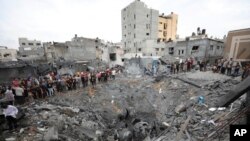 Warga Palestina memeriksa puing-puing bangunan yang hancur pasca serangan udara Israel di Deir al Balah, Jalur Gaza pada 27 Oktober 2023. (Foto: AP)