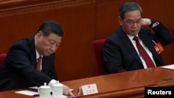 中国领导人习近平和中国总理李强在北京人大会堂出席全国人大会议闭幕式期间习近平在投票。（2024年3月11日）