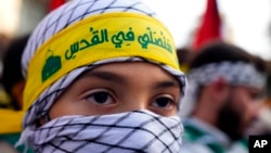 Pripadnik Hezbolahove izviđačke grupe Al-Mahdi u Bejrutu, sa trakom na glavi na kojoj je ispisana poruka "Molićemo se u Jerusalimu", na skupu podrške Palestincima, 27. oktobar (Foto: AP/Bilal Hussein)