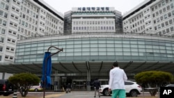 A medical worker walks to enter Seoul National University Hospital in Seoul, South Korea, Feb. 29, 2024. South Korea’s government made a last appeal to junior doctors to end a walkout, with hours left to go before the Thursday deadline.