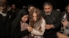 Palestinian activist Ahed Tamimi, center, is supported by her mother after she was released from prison by Israel, in the West Bank town of Ramallah, Nov. 30, 2023. A U.N. report on July 31, 2024, says prisoners and hostages of Israel and Hamas are subjected to mistreatment.