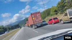 Doble fila de autos y camiones que esperan para surtir combustible obstaculizan el tránsito en una importante autopista en Venezuela.