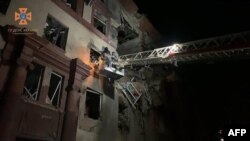 Esta fotografía publicada por el Servicio Estatal de Emergencia de Ucrania muestra a los rescatistas ucranianos trabajando en un edificio residencial parcialmente destruido después de los ataques con misiles rusos en Zaporizhzhia, el 18 de octubre de 2023.