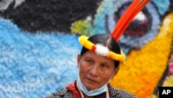ARCHIVO - Una indígena de la Amazonía espera afuera de la Corte Constitucional, en Quito, Ecuador, el lunes 18 de octubre. 2021.