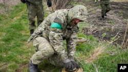 Український сапер знешкоджує протитанкову міну в місті Ірпінь біля Києва 19 квітня 2022 р.