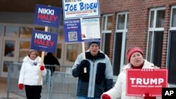 ARCHIVO - Simpatizantes de candidatos frente a un centro de votación en las elecciones primarias del 23 de enero de 2024, en Windham, New Hampshire. El supermartes a la vista con los principales contendientes presidenciales ya pareciendo estar listos.