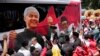 FILE - Para pendukung paslon capres-cawapres Pilpres 2024 Ganjar Pranowo dan Mohammad Mahfud, mengelilingi bus kampanye saat mendaftarkan diri di gedung Komisi Pemilihan Umum di Jakarta, 19 Oktober 2023. (AP/Achmad Ibrahim)