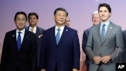 2023年11月16日,在旧金山举行的亚太经合组织峰会上,日本首相岸田文雄(左)、中国国家主席习近平(中)和加拿大总理特鲁多(右)合影留影。(美联社)