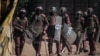 FILE - Kenyan Police officers watch protesters blocking a street during a rally called by opposition leader Raila Odinga, in Kibera, Nairobi, March 27, 2023. A court ruled on Jan. 26, 2024 against a government's plan to deploy police officers to Haiti.