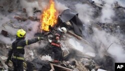 2024年1月23日，烏克蘭哈爾科夫的救援人員在被俄羅斯火箭損壞的建築物現場工作。（美聯社照片）