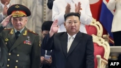 김정은 북한 국무위워장과 세르게이 쇼이구 러시아 국방장관이 나란히 27일 밤 평양에서 열린 열병식을 참관하고 있다. AFP PHOTO/KCNA VIA KNS.