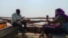 Journalist Varsha Singh, right, conducts an interview in Bharuch district, Narmada estuary, Gujarat, India, in 2023. (Rizwan Mirza for VOA)